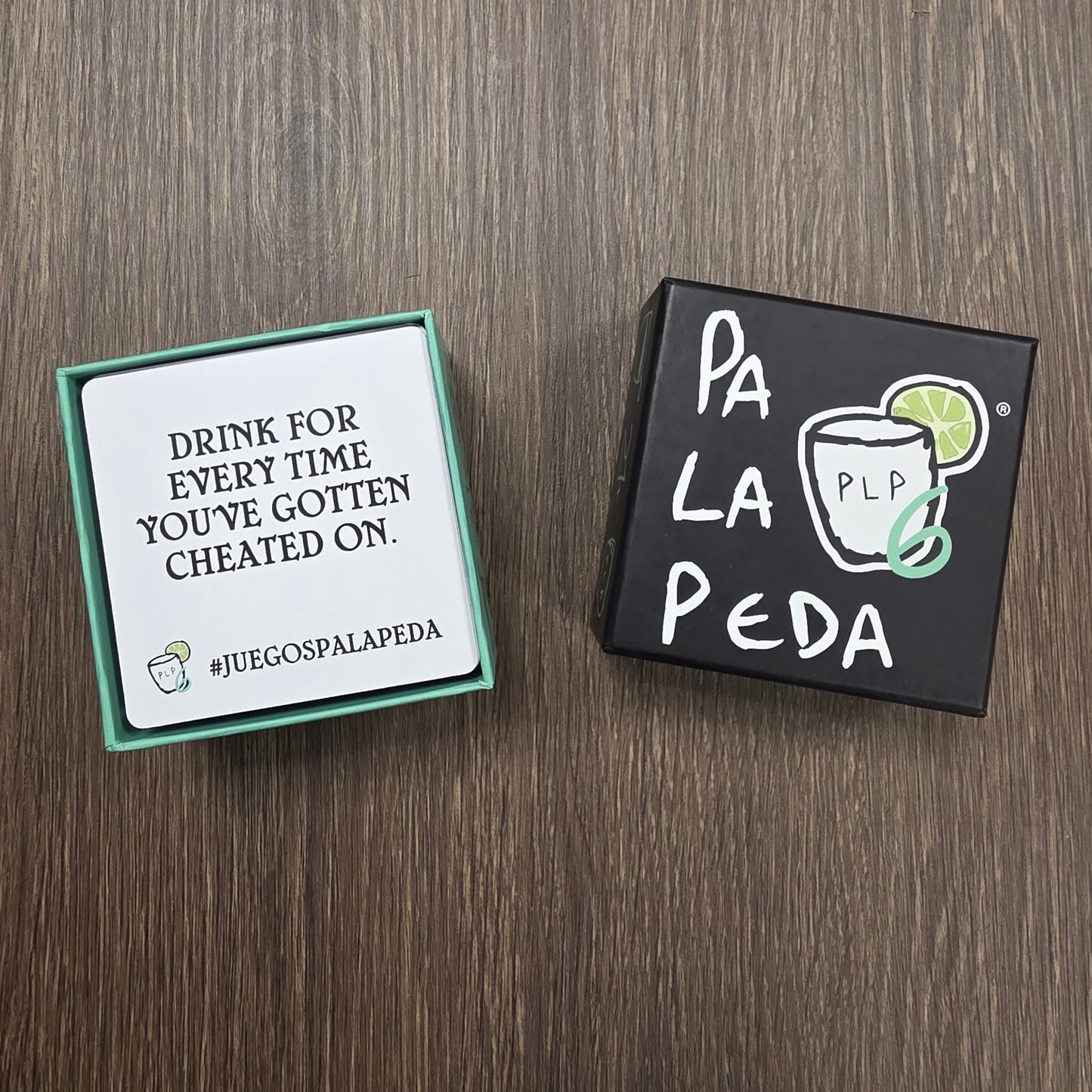 Two card games on a wooden surface, one with 'Pa La Peda' branding.