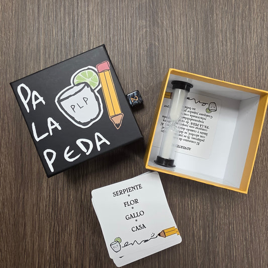 Small black box with a drawing of a glass and a lime, open to reveal a card and a small container on a wooden surface.