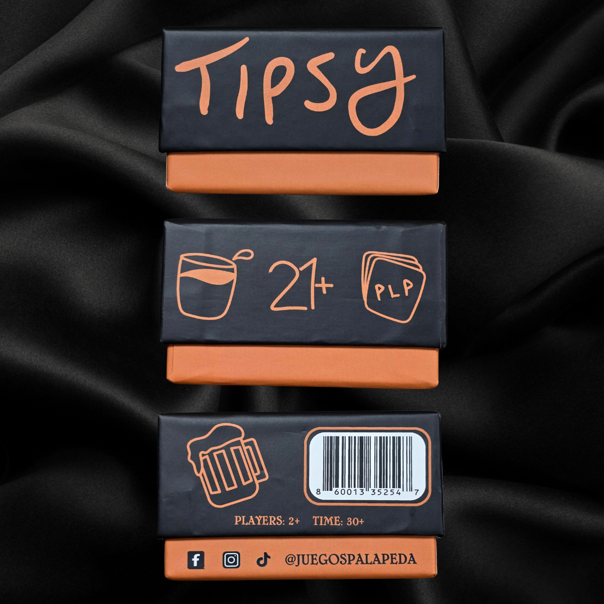 Three 'Tipsy' product boxes with branding and design elements on a black fabric background.