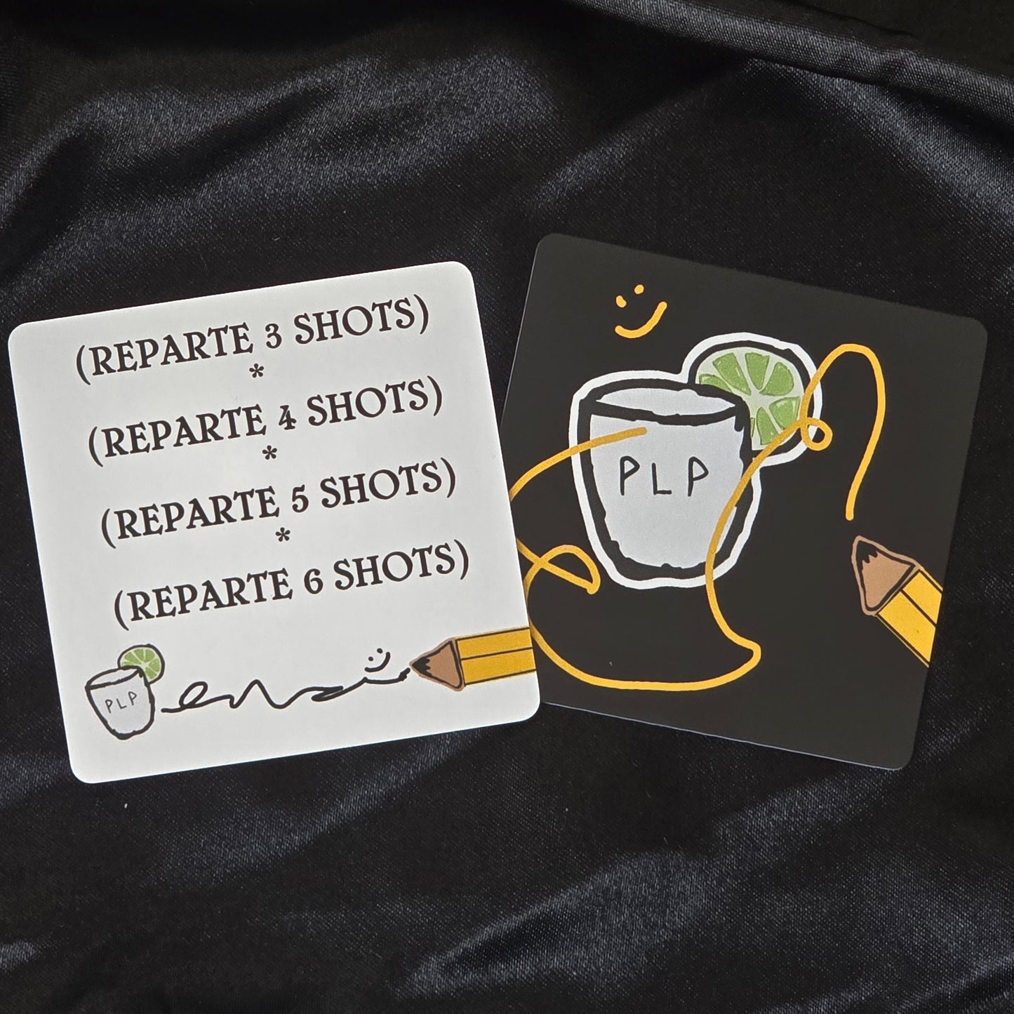 Two cards with text and graphics on a black fabric background