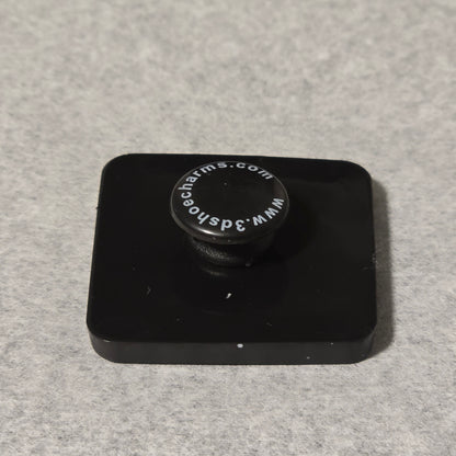Black square object with a circular component on a gray background
