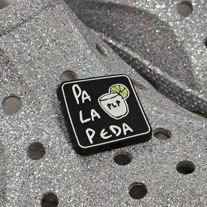 Black square pin with 'Pa La Peda' text and a logo on a metallic surface