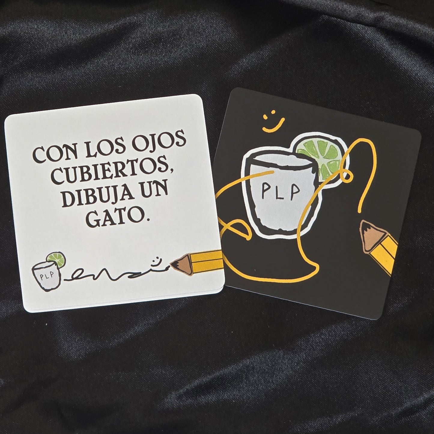 Two cards with illustrations and text on a black fabric background