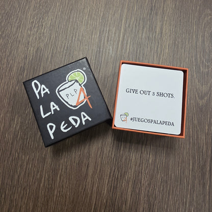 Two small boxes on a wooden surface, one with text and the other with a graphic design.