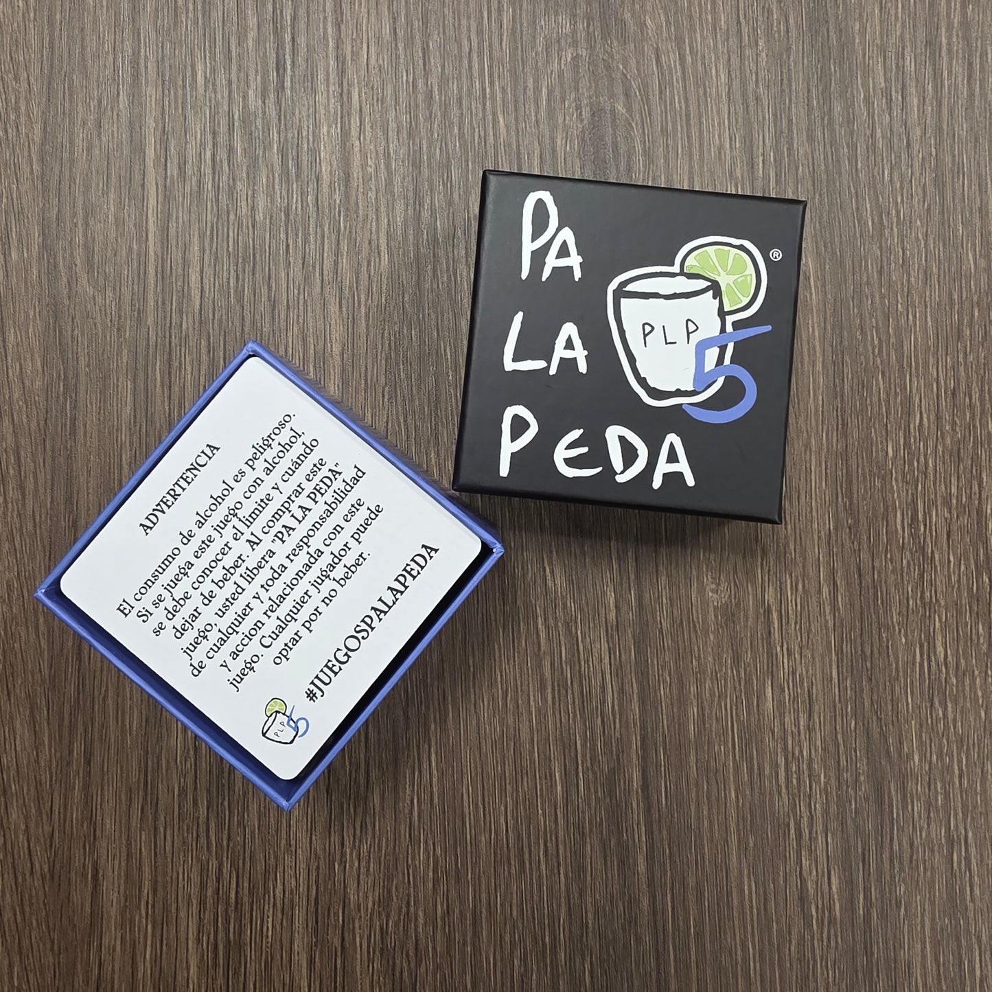 Two small boxes with 'Pa La Peda' branding on a wooden surface