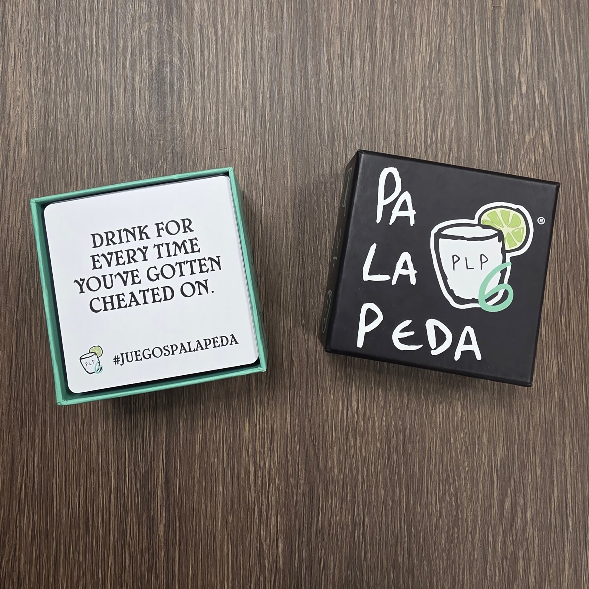 Two card games on a wooden surface, one with 'Pa La Peda' branding.