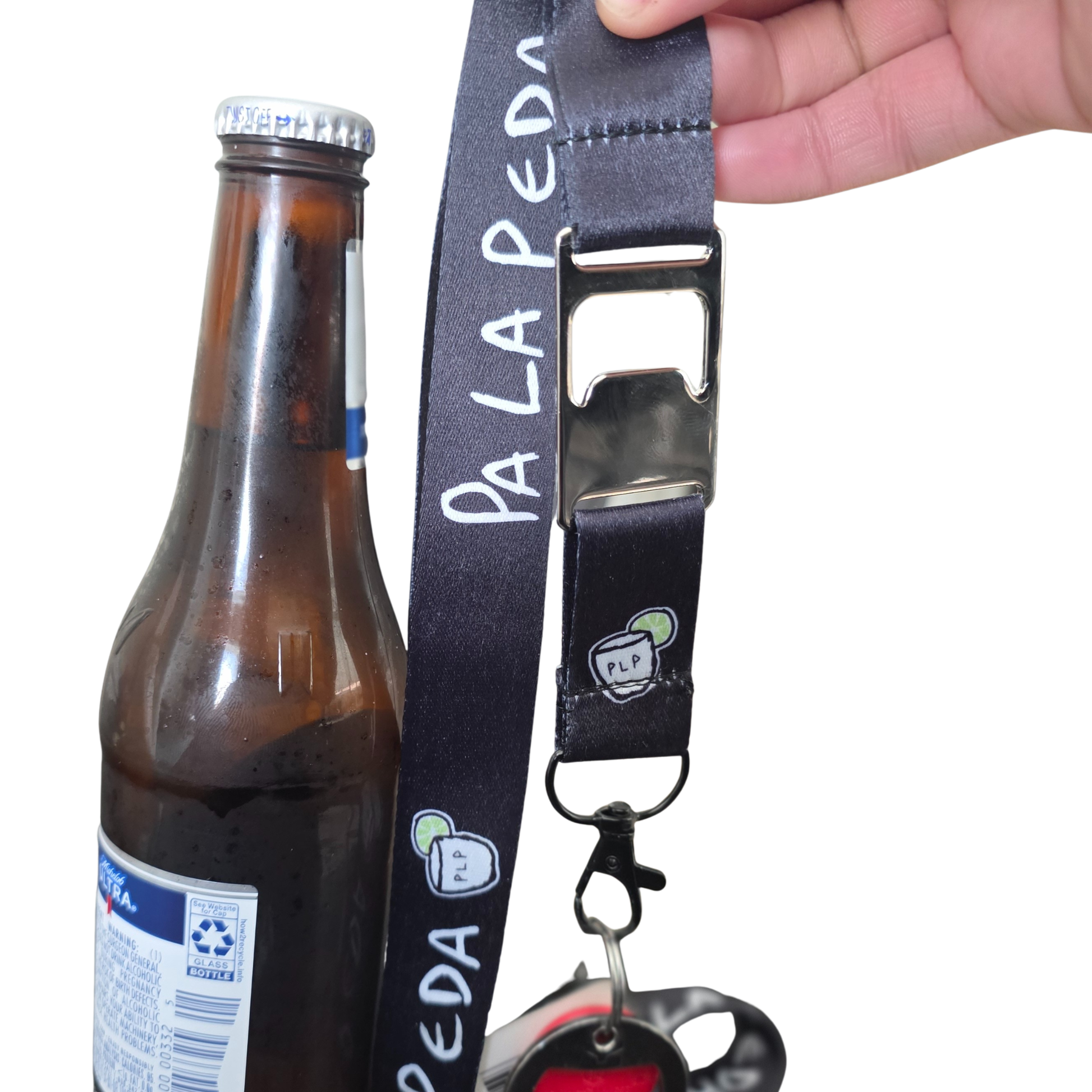 Lanyard with bottle opener and keychain next to a beer bottle on a white background