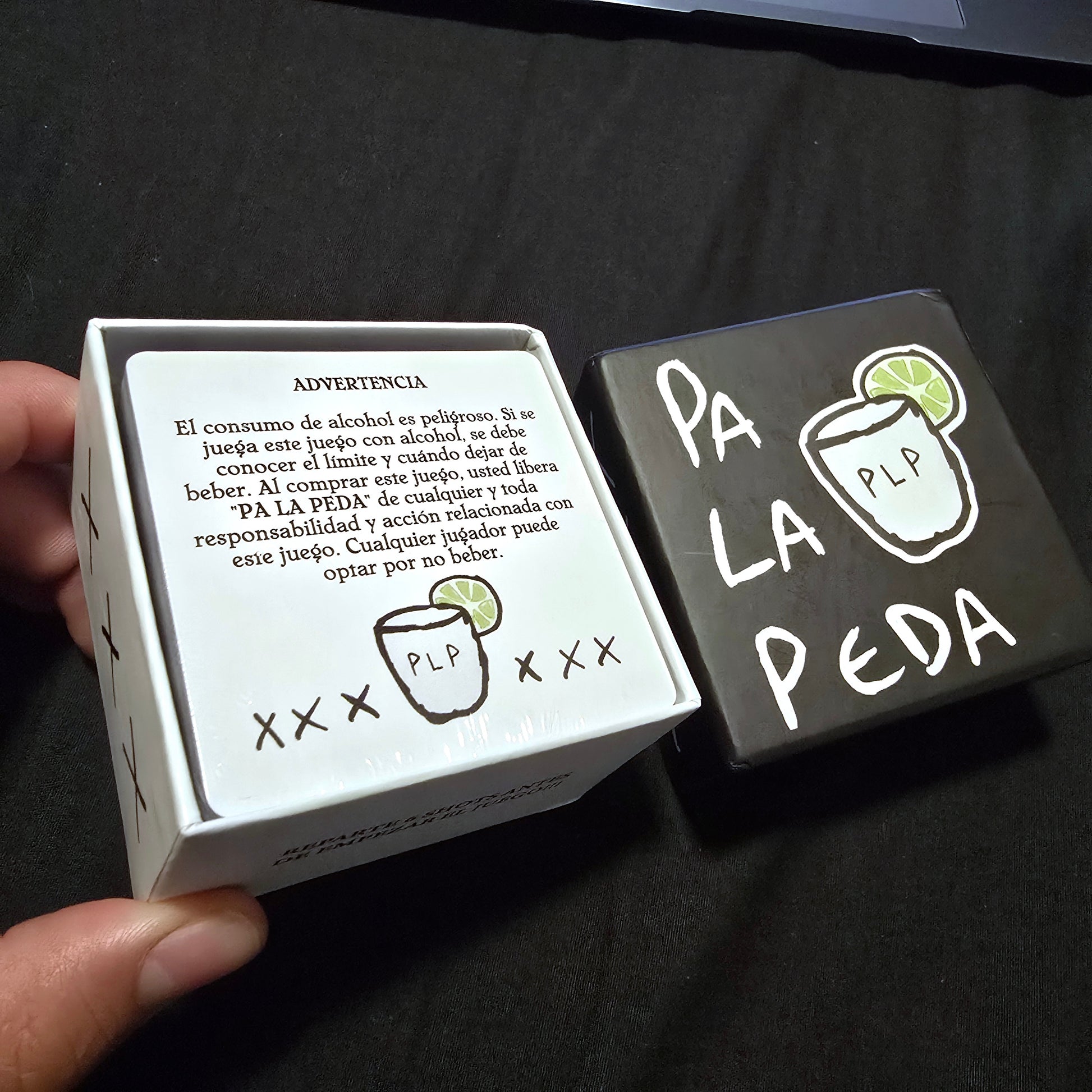 Card game box with text and graphics on a dark surface